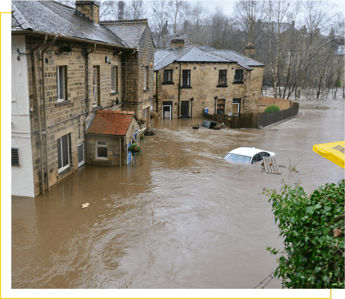 A flooded area with houses and trees in the background.